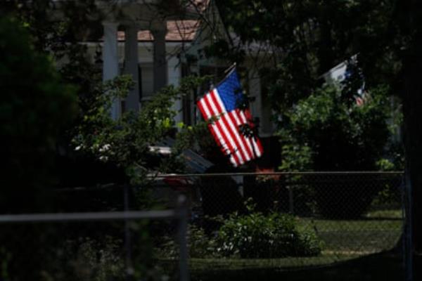 a US flag flies in yard 